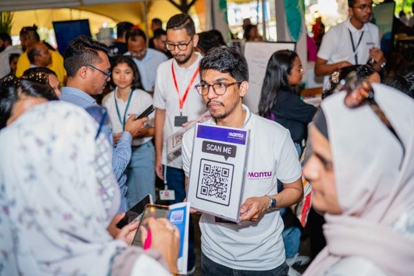 Participant tenant un panneau « Scan me » dans la foule du JobFair